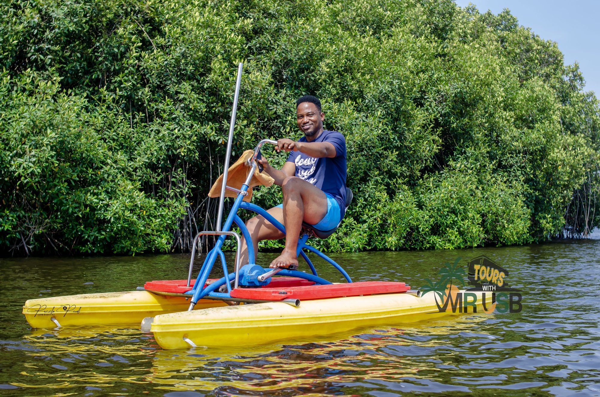 A guest pedalling a hydrobike across the water beside the mangroves