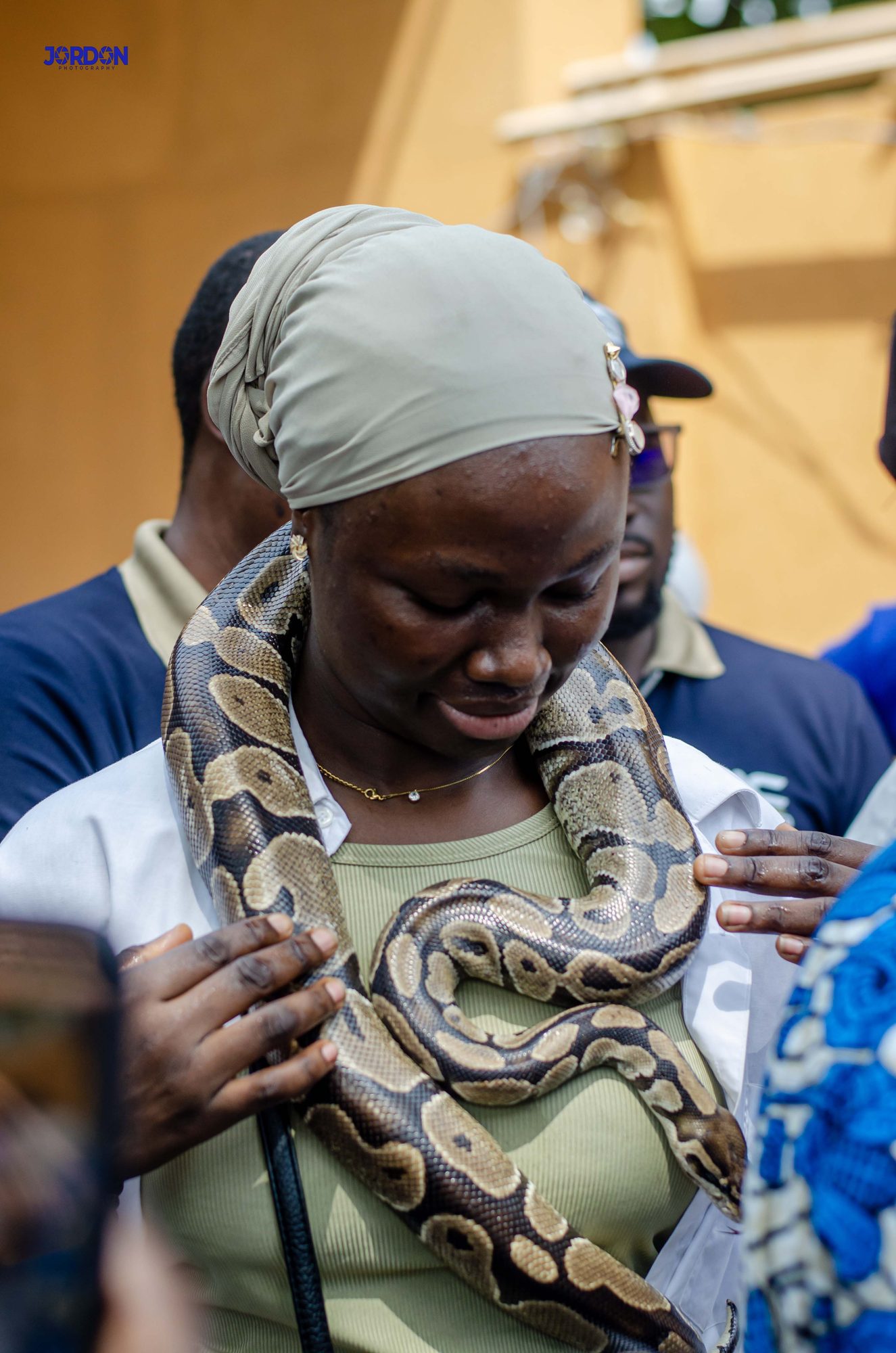 A guest at the Temple of Pythons, python resting across her shoulders