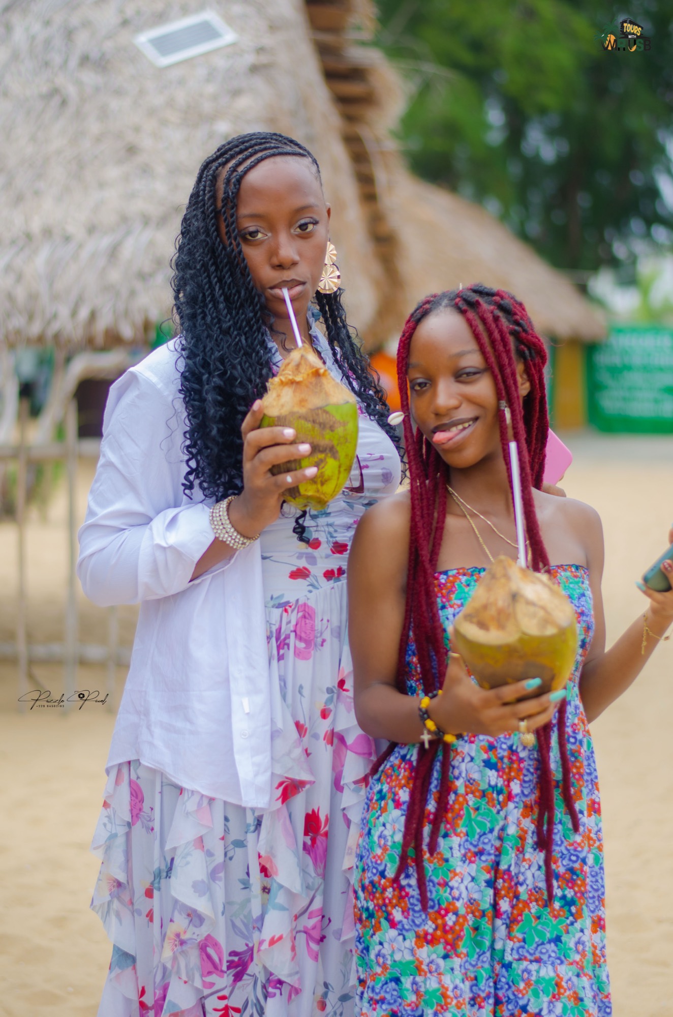 Two guests sipping fresh coconuts on the sand between painting sessions